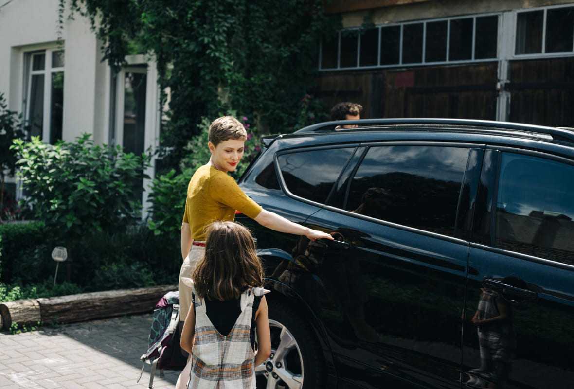 Frau mit Tochter an Auto