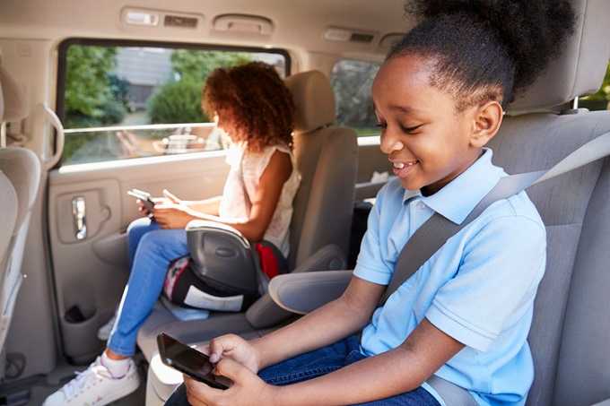 Kinder auf Sitzerhöhungen im Auto