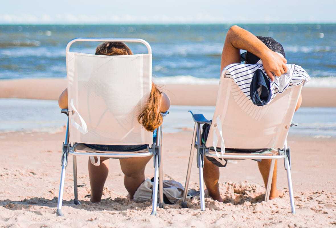 Mann und Frau auf Liegestühlen am Strand