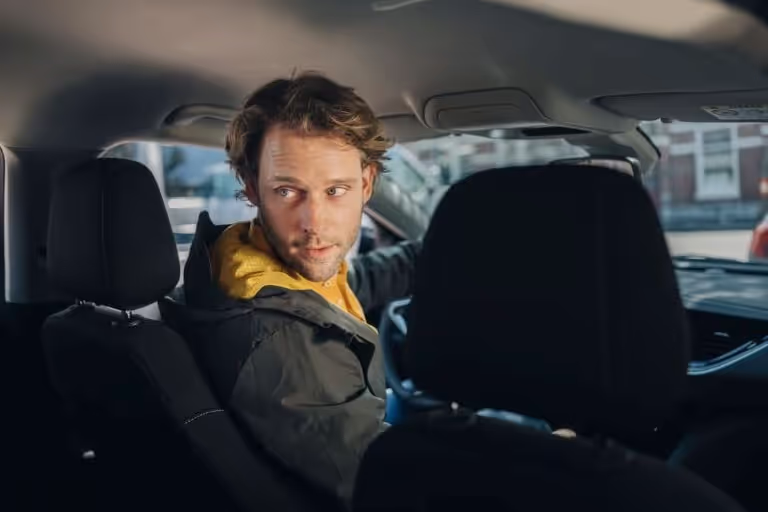 Mann macht im Auto einen Schulterblick nach hinten