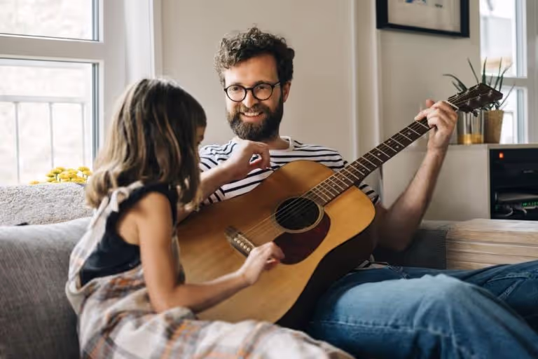 Mann spielt mit Kind Gitarre