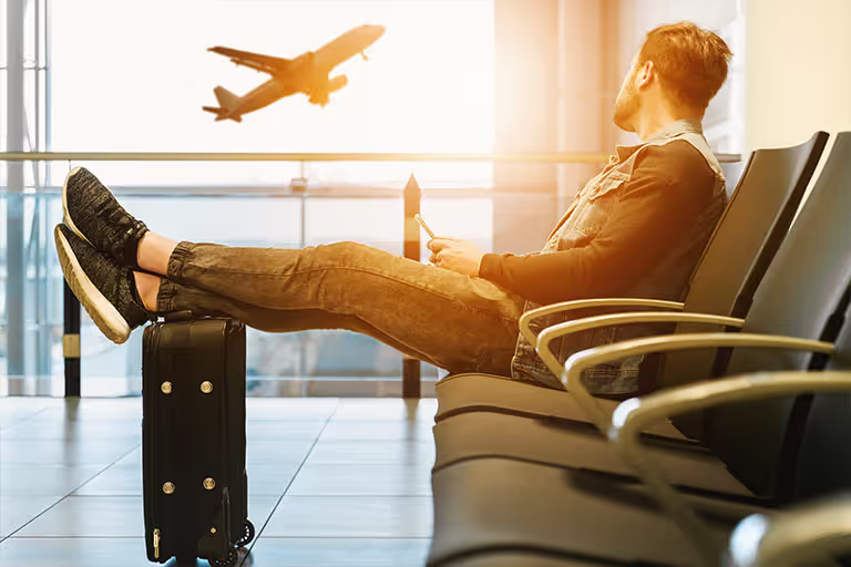 Mann wartet am Flughafen auf seinen Flug.