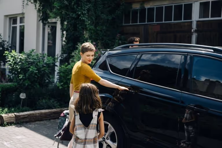 Frau mit Kind am Auto